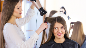 Cabeleireira secando cabelo da cliente